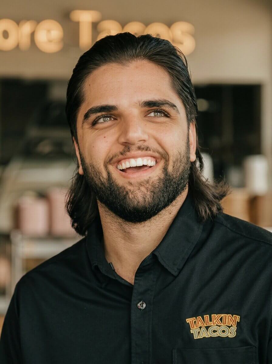 Mo Farraj, owner of Talkin' Tacos, smiling in his restaurant